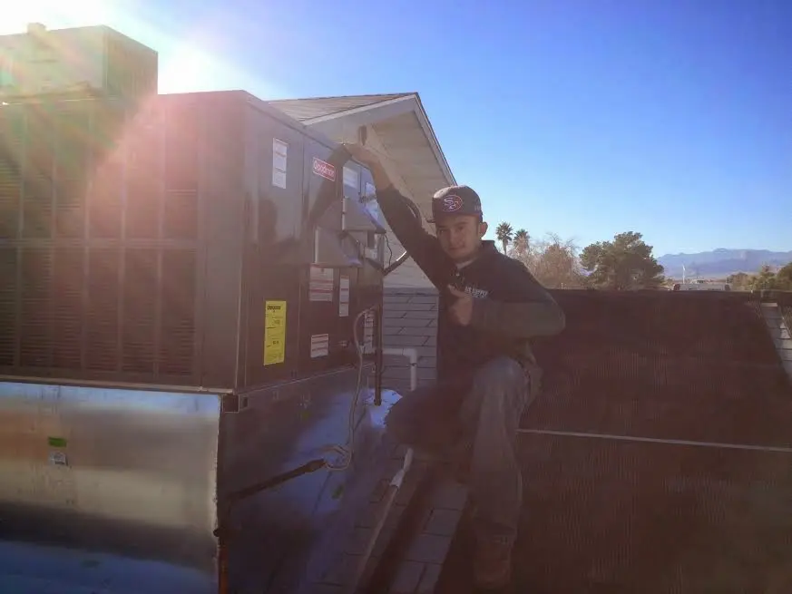 HVAC technician performing Boiler Repair on a rooftop unit in Beatrice